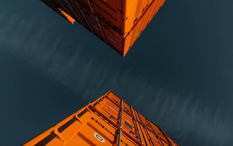 Especialista aduanero revisando documentación de importación frente a dos monitores